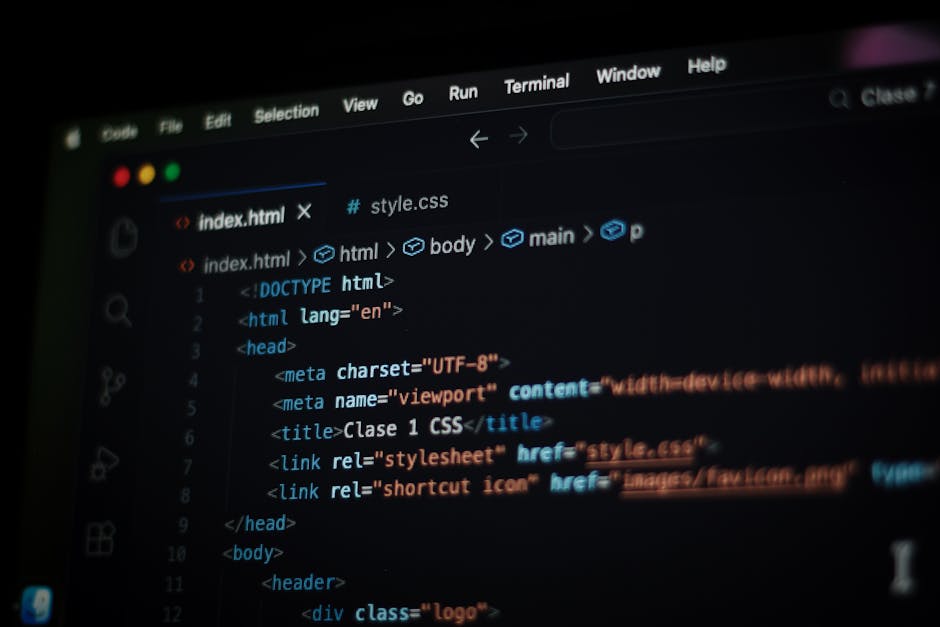 A close-up photograph of a computer screen displaying a web development code editor with dark background and colorful syntax highlighting. The code appears to be HTML, with tags such as <html>, 